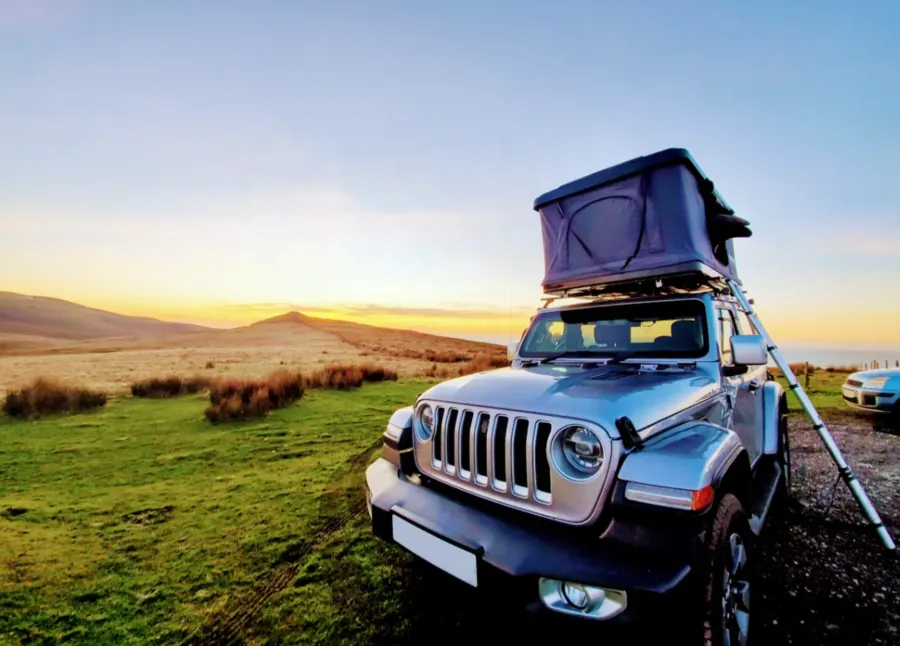 Rooftop tent on SUV at sunset
